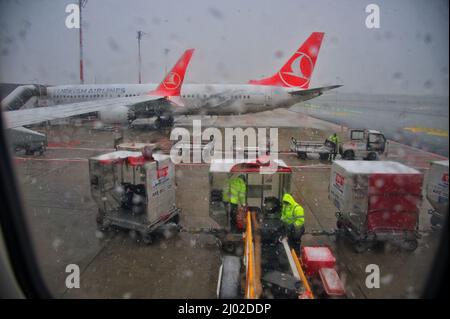 Loading luggage on a plane during rainy day - view from window Stock Photo