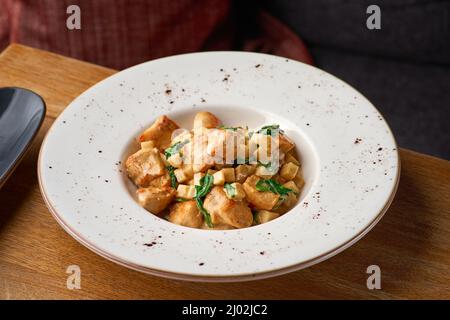 French cuisine a fricassee of Turkey with mushrooms, cream sauce on wooden table. Stock Photo