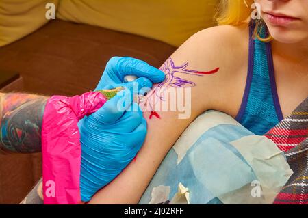 the process of tattooing on the forearm close-up Stock Photo