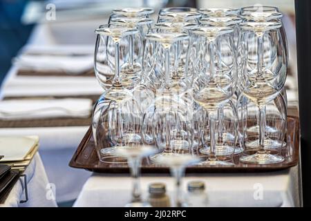 stacks of clean empty glasses on trays in a street cafe, close-up Stock Photo