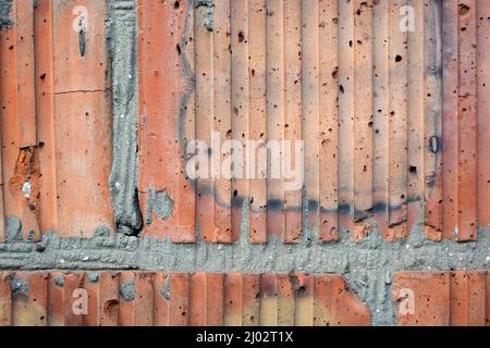 Building materials, brickwork made of red-yellow bricks and gray cement. Construction background. Stock Photo