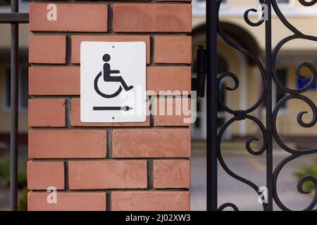 Disability sign on a brick wall. Urban environment. Stock Photo