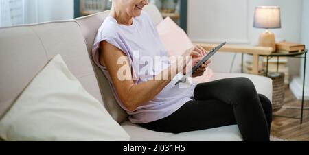 elderly woman looking at the screen of her digital tablet . Stock Photo