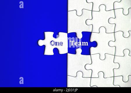 Text on missing jigsaw puzzle - One team. Motivational and team concept Stock Photo