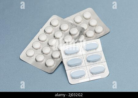 Colorful of tablets and capsules pill in blister packaging arranged on the blue background. Stock Photo