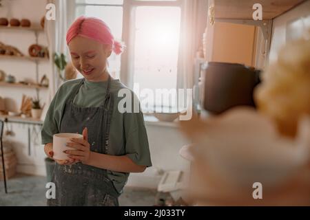 Positive female artisan having ceramics in workshop Stock Photo