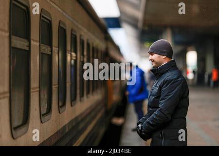 Kyiv, Ukraine. 13th Mar, 2022. A man is seen standing outside a train as he communicates with loved ones inside the train at the Kyiv railway station. The European Union has put in place a temporary protection mechanism for Ukrainian refugees who were forced to leave Ukraine due to the Russian invasion. Refugees were allowed to legally live and work in EU countries for up to three years. (Credit Image: © Mohammad Javad Abjoushak/SOPA Images via ZUMA Press Wire) Stock Photo