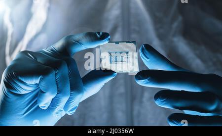 Hands in gloves hold Microchip testing microelectronics at a Ultra Modern Electronic Manufacturing Factory Stock Photo
