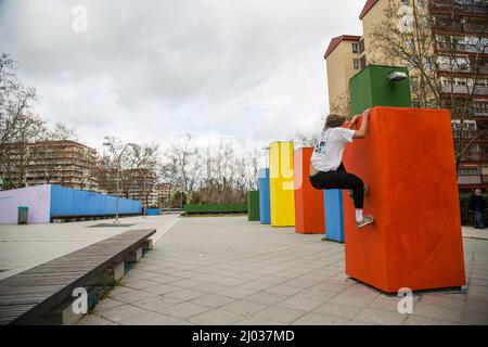series of photos of young man jumping practicing parkour in the street jumping between color blocks Stock Photo