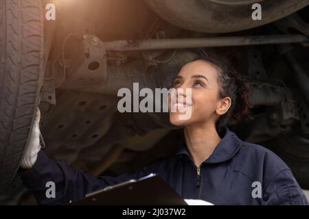 Happiness American Black woman worker. Mechanic lady staff checking car working in auto garage. Stock Photo