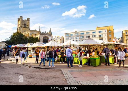 Stalls at Cambridge Market Square with Great St Mary's Church in the background, Cambridge, Cambridgeshire, UK Stock Photo