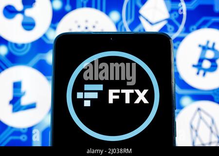 FTX is a cryptocurrency exchange. FTX logo on smartphone screen against the background of the main cryptocurrencies. Stock Photo