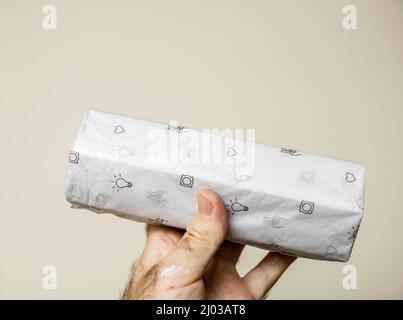 Paris, France - Dec 4, 2021: Electrician POV male hand holding packaged with special paper new luminaire made by Wever and Ducre light Stock Photo