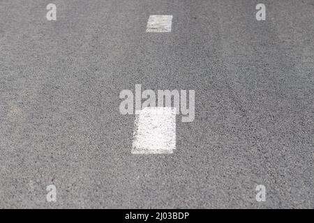 Road markings. An intermittent white stripe on an asphalt road. Urban transport Stock Photo