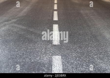 Road markings. An intermittent white stripe on an asphalt road. Urban transport Stock Photo