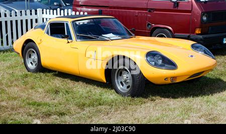 Three-quarters front view of a  Yellow, 1968, Marcos GT, on display at the 2021 London Classic Car Show Stock Photo