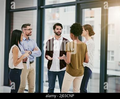 Hes sure to have everyones buy in. Shot of a group of colleagues having a meeting in a modern office. Stock Photo
