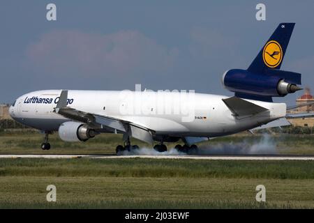 Lufthansa Cargo McDonnell Douglas MD-11F (REG: D-ALCK) touching down and burning rubber on runway 31. Stock Photo