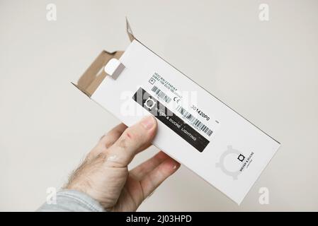 Paris, France - Dec 4, 2021: Electrician POV male hand holding packaged new luminaire made by Wever and Ducre lighting - Hexo Mini version with GU10 light bulb Stock Photo