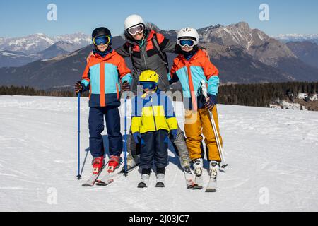 Happy family, skiing in Italy on a sunny day, kids and adults skiing together. Family vacation Stock Photo