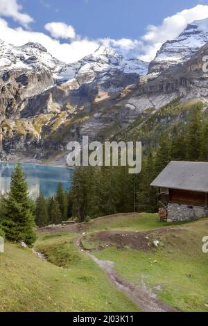 Amazing tourquise Oeschinnensee lake, wooden chalet and Swiss Alps, Berner Oberland, Switzerland. Stock Photo