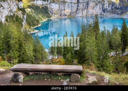 Amazing tourquise Oeschinnensee lake, wooden bench and Swiss Alps, Berner Oberland, Switzerland. Stock Photo