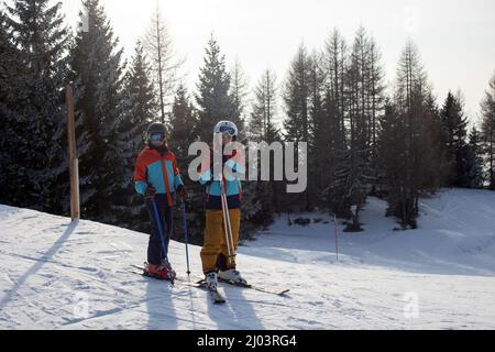 Happy family, skiing in Italy on a sunny day, kids and adults skiing together. Family vacation Stock Photo