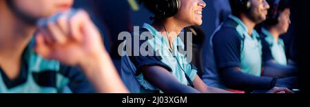 Young woman with headphones plays computer game in internet club Stock Photo