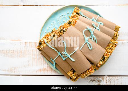 Delicious oatmeal bars with granola fruiots and nuts on blue plate Stock Photo