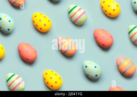 Happy Easter. Top view of creative pattern made of colored easter painted eggs over blue background Stock Photo