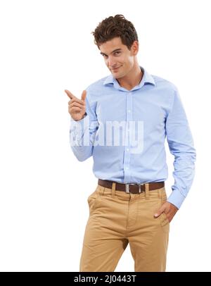 I have the perfect space for you. Portrait of a handsome young man in a studio pointing off camera. Stock Photo