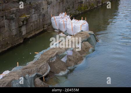 Sandbags for artificial barrier in a river protecting a construction site Stock Photo