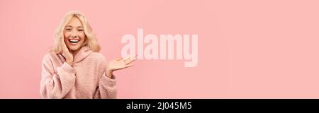 Happy young blonde woman showing copy space Stock Photo