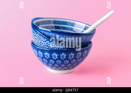 Chinese bowls with spoon on color background Stock Photo
