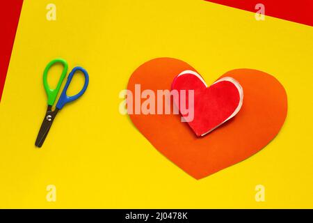 Top view of papercraft red heart and scissors on yellow background Stock Photo