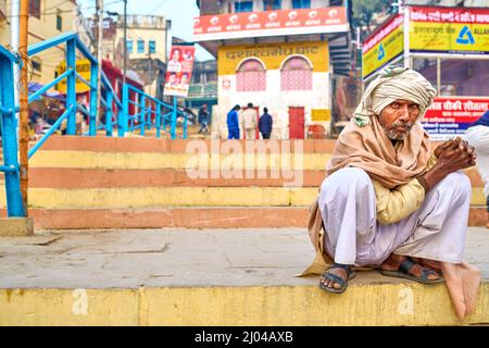 India. Varanasi Benares Uttar Pradesh. Man on a ghat by the river Ganges Stock Photo