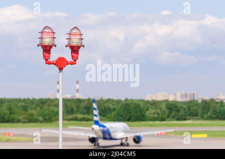 Red warning warning light with the light on, against the blue sky. Close up aircraft warning light on top of a highrise of building airport. for safet Stock Photo