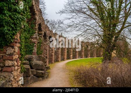 Great view of the gravel walkway along the artificial ruins of the Roman water aqueduct by Nicolas de Pigage in the famous English landscape garden of... Stock Photo