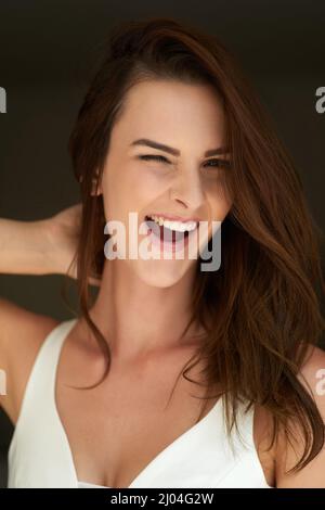 Do you like what you see. Studio portrait of an attractive young woman winking against a black background. Stock Photo