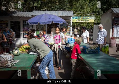 Picture of a female merchants and sellers in the Ukrainian city of Lviv, selling and negotiating on stands, buying and selling fruits and vegetables. Stock Photo