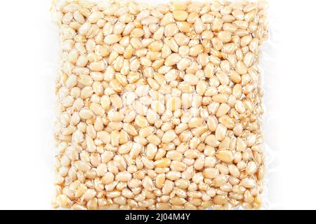 Pine nuts in a transparent vacuum package over a white background Stock Photo
