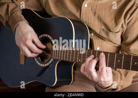 man playing a six-string guitar, close-up Stock Photo