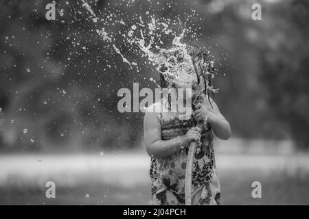 Child Playing In Water During Summer Time Stock Photo