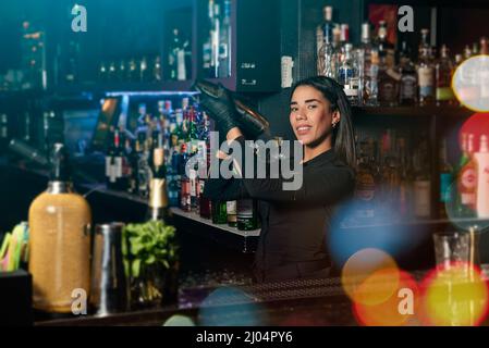 Latin brunette waitress prepares a cocktail at the bar. profession Stock Photo