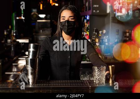 Latin brunette waitress prepares a cocktail at the bar. profession Stock Photo