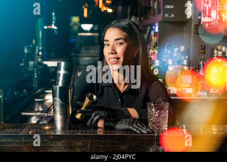 Latin brunette waitress prepares a cocktail at the bar. profession Stock Photo