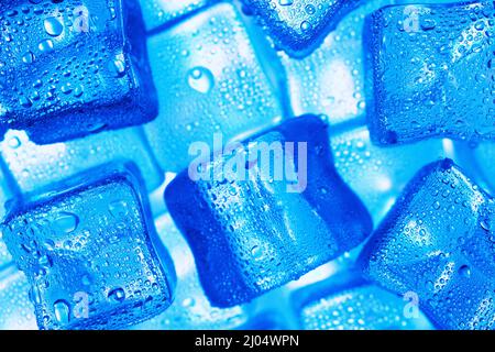 Ice cubes with blue backlight in the freezer close-up in full screen selective focus Stock Photo