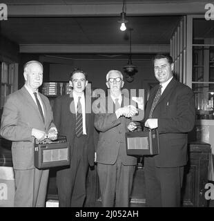 1960s, historical, two eldery gentlemen, long serving company employees of Watts Brothers Limited - establised in 1915 - being congratulated on their retirement from the business and receving gifts of the latest portable Hacker transistor radios, Scotland, UK. In the late 1920s, the Hacker Bros had founded Dynatron, but following its take over by Ekco in 1955, the brothers established Hacker Rado Limited in 1959, later being awarded two Royal Warrants of Appointment, a prestigious honour. Hacker radios, are considered by many to be the best ever made British radios. Stock Photo