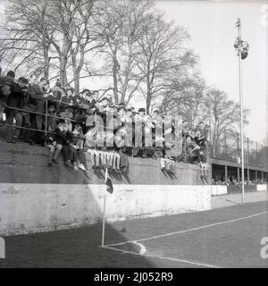 1960s, historical, young football supporters, some wearing scarfs, on a terrace at a corner of the Manor Ground, the home of Oxford United footbal club from 1925 to 2001. The club was formed in 1893 as Headington, with the suffix United added in 1911. The name Oxford United was adopted in 1960. Here we see a supporters, mainly yougsters, some sitting down, others standing against the metal barriers. Stock Photo