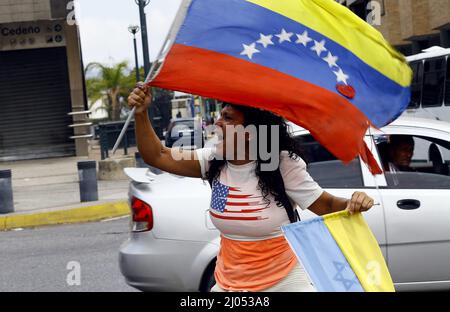 Valencia, Carabobo, Venezuela. 16th Mar, 2022. March 16, 2022. A woman carrying the flags of Venezuela, Ukraine and Israel, shouts slogans for world peace and calls on passersby to condemn Russia's invasion and express solidarity with Ukraine. In Valencia city, Carabobo state. Photo: Juan Carlos Hernandez (Credit Image: © Juan Carlos Hernandez/ZUMA Press Wire) Stock Photo
